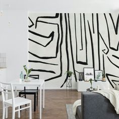 a living room filled with furniture and a painting on the wall