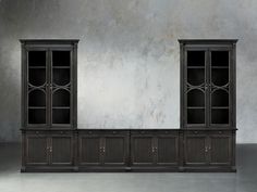 an empty room with two black bookcases and a gray wall in the background