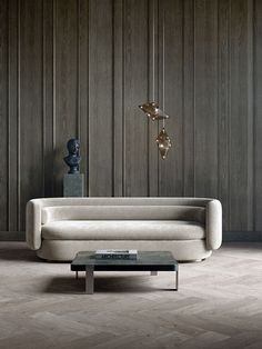 a living room with wood paneling and a white couch next to a coffee table