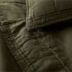 an image of a close up view of a quilted comforter with buttons on it