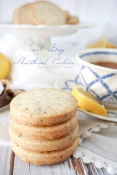 a stack of cookies sitting on top of a table next to a cup of tea