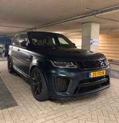a black range rover parked in a parking garage