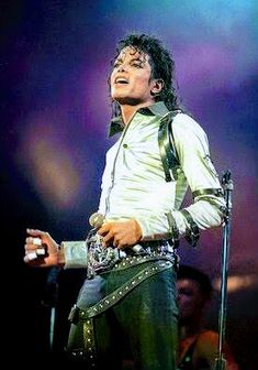 michael jackson performing on stage with his microphone and singing into the air in front of him