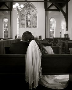 a bride and groom are sitting in the pews of a church, facing each other