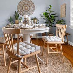 a dining room table with two chairs and a rug on the floor in front of it