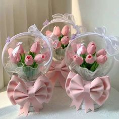 three clear vases with pink flowers in them