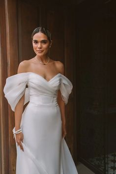 a woman in a white dress posing for the camera