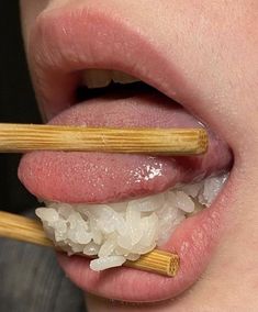 a person with chopsticks sticking out of their tongue