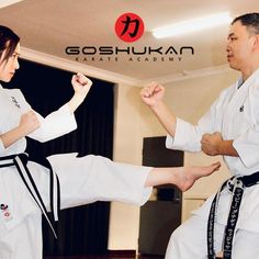 two people doing karate moves in a room