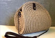 a straw bag with black straps on a table