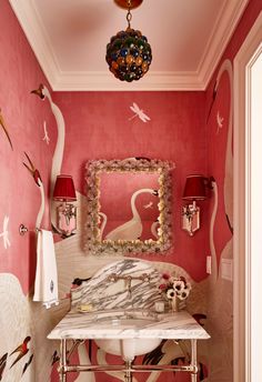 a bathroom decorated in pink and white with birds on the wall