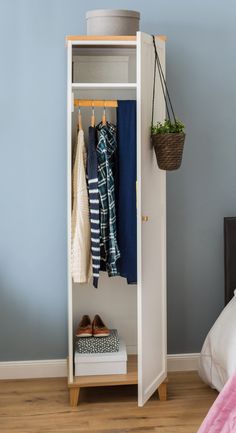an open closet with clothes and shoes hanging on the rack, next to a bed