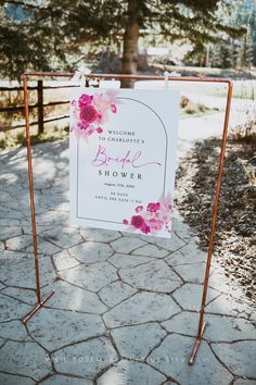 a sign that says welcome to the bride and groom with flowers on it in front of a tree
