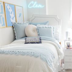 a white bed topped with pillows and blankets