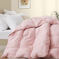 a pink comforter and pillows on a bed