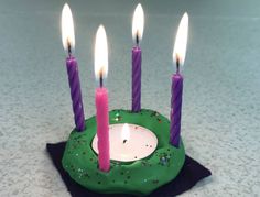 a small green cake with lit candles on it