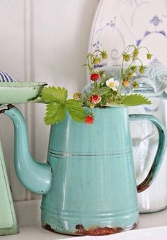 a blue watering can with flowers in it