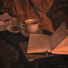 an open book and two cups on a table