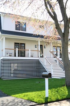 a white house with black roof and stairs