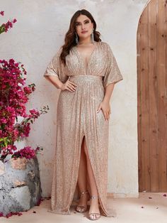 a woman standing in front of a wall wearing a gold dress and heels with her hands on her hips