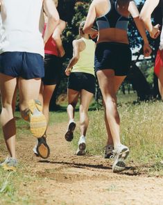 a group of people running down a dirt road