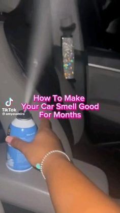 someone is spraying something out of the car's air freshener bottle with their hand