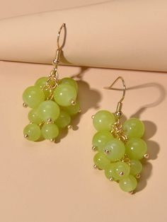 a pair of green grapes hanging from earrings