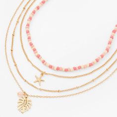 Layer up on cool tropical vibes with this multi-strand necklace. Four gold-tone chains include a pink-colored seed bead row, a starfish charm dangler, a plain chain, and a monstera palm tree leaf with a pink beaded accent. Finish: Gold-tone Lengths: 11" - 16" + 3" extender Closure: Lobster clasp Material: Metal - Claire's Pink Bead Gold Starfish & Monstera Palm Leaf Multi Strand Choker Necklace Jewelry Gift Basket, Preppy Necklaces, Beachy Necklace, Preppy Accessories, Surf Jewelry, Beachy Jewelry, Preppy Jewelry, Jewelry Accessories Ideas, Fashionable Jewelry