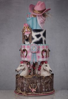 a three tiered cake decorated with horses and cowboy hats on it's sides