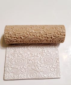 a roll of wax paper sitting on top of a white countertop next to a rolled up piece of toilet paper