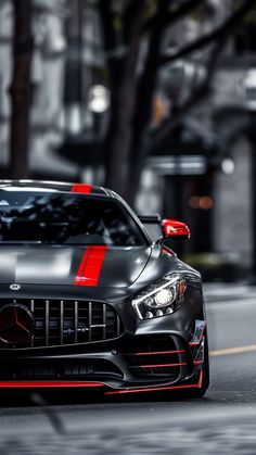 a black sports car with red stripes on the front is driving down the street in an urban area