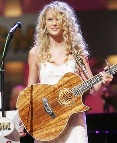 a woman with long blonde hair holding a guitar