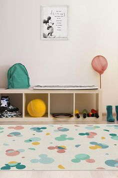 a child's playroom with toys and bookshelves on the floor in front of a white wall