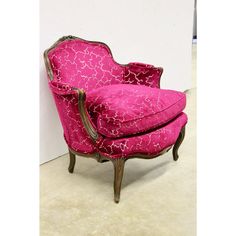 a pink chair sitting in front of a white wall