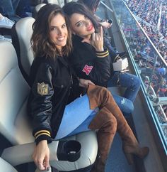 two women sitting in the stands at a baseball game