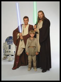 two men and a child are dressed up as star wars characters, one is holding lightsabes