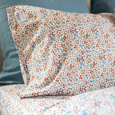 a close up of a bed with two pillows and a pillow case on top of it