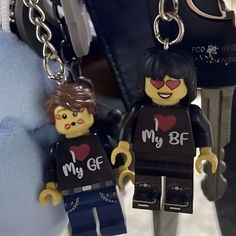 two lego key chains are attached to the back of someone's body and they have hearts on them