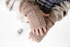 a close up of a person wearing knitted gloves