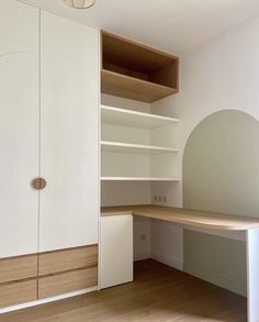 an empty room with white walls and wooden flooring is pictured in this image, there are shelves on either side of the closet