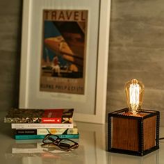 a lamp that is sitting on top of a table next to some books and glasses