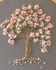 a cross stitch tree with pink flowers on it