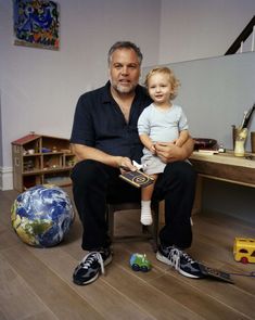 a man sitting on a chair holding a small child