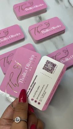 a person holding up some pink business cards