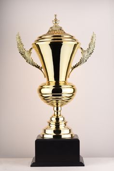 a golden trophy on a black pedestal with a gold laurel decoration around it's base