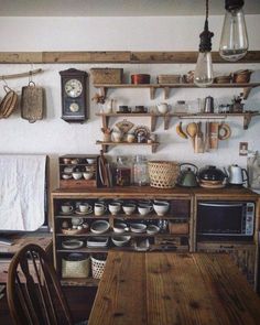 an old fashioned kitchen with wooden table and shelves