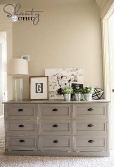 a room with a dresser and pictures on the wall