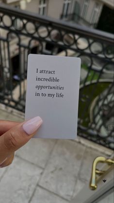 someone holding up a card that says i attract incredible opponents in to my life on the balcony