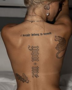 the back of a woman's body with tattoos on her upper and lower half