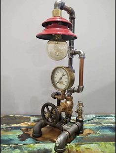 an old fashioned steam engine lamp with a red light on it's head and gauge